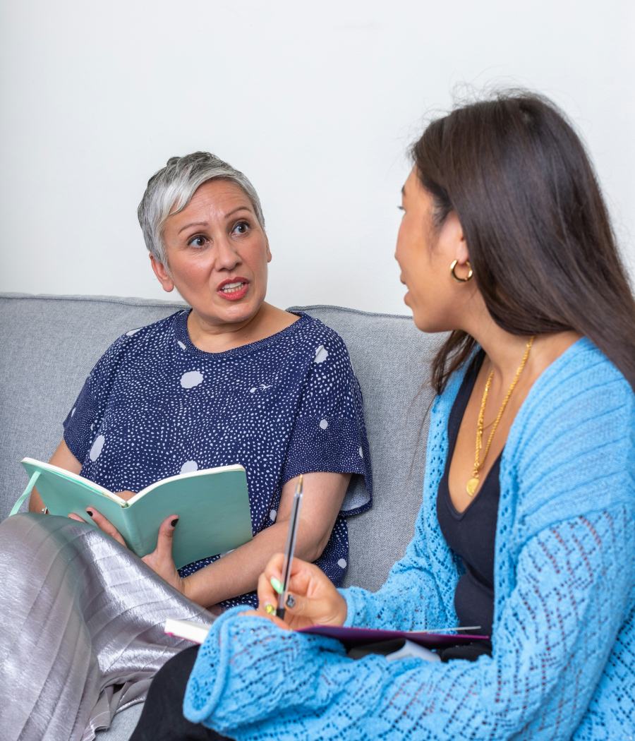 An experienced woman talking with a younger woman who is taking notes